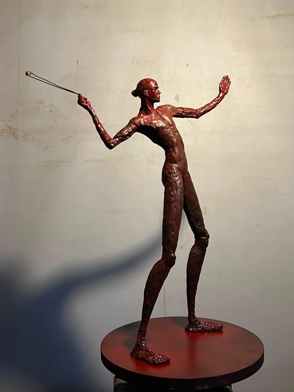 Freedom Throw, Cast bronze, oxblood patina, steel sling with gilded brass shot, painted steel base
